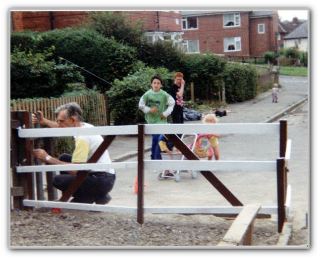 Uncle Ted fixing fence with Cousin Mark in background